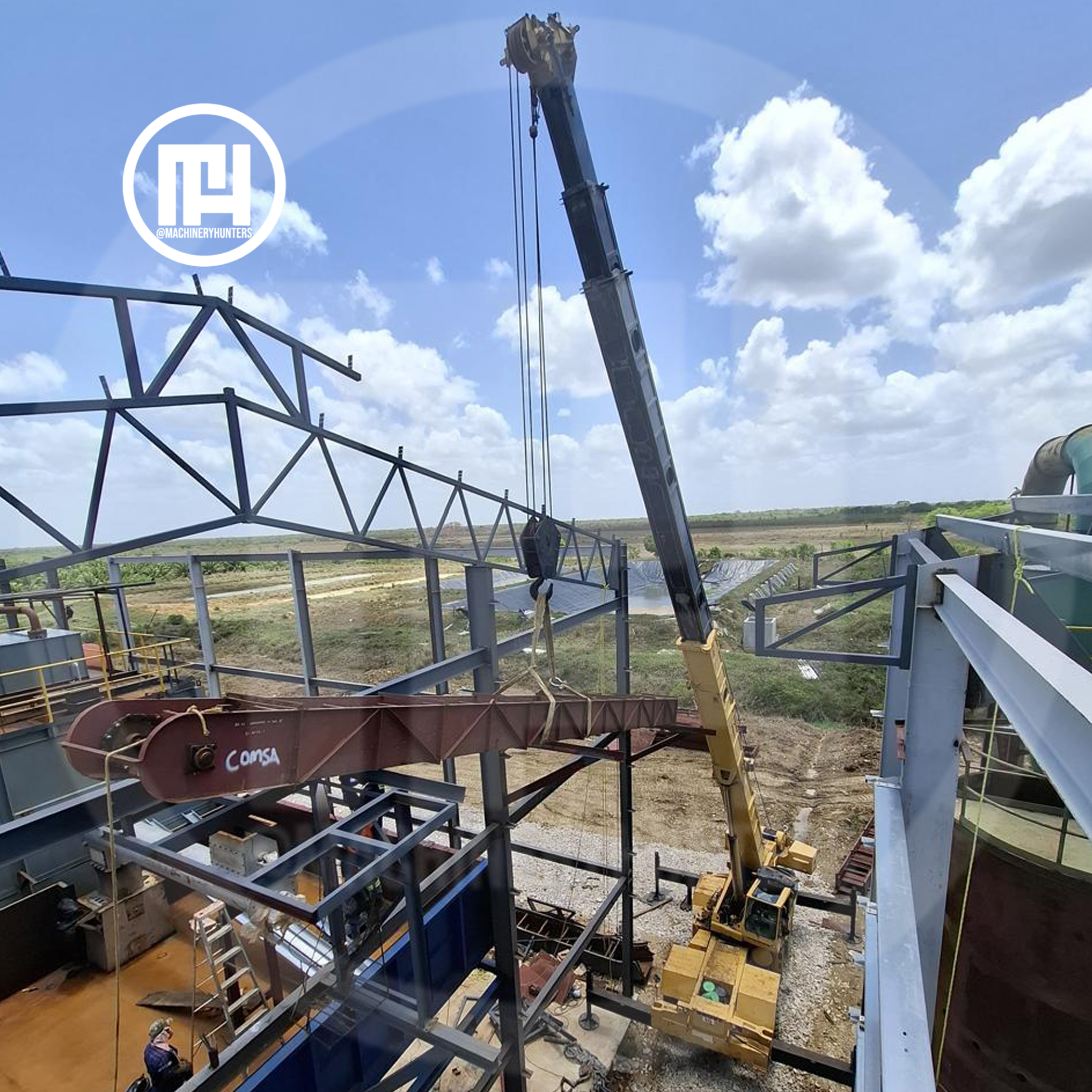 Grúa Grove RT740 trabajando en montaje de estructura metálica desde vista aérea