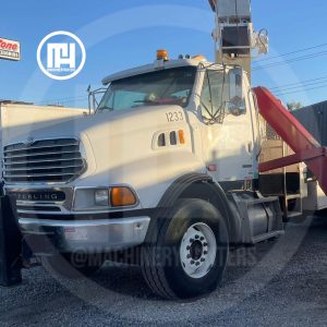 Grúa titán Terex montada sobre camión Sterling L9500 color blanco vista frontal, estacionada en agencia Machinery Hunters.