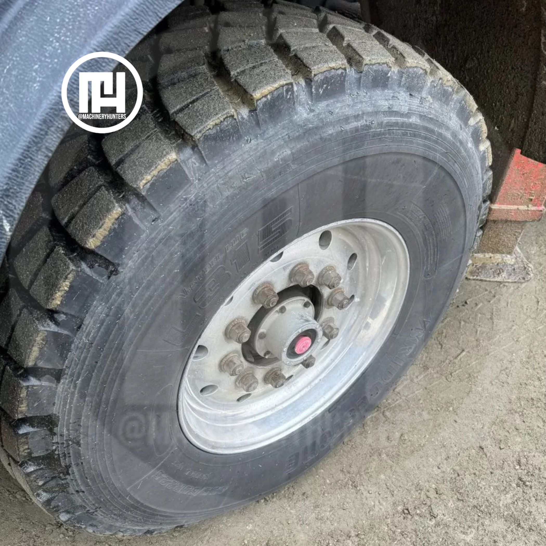 Llanta trasera de camión MACK con dibujo profundo en buen estado, vista lateral.